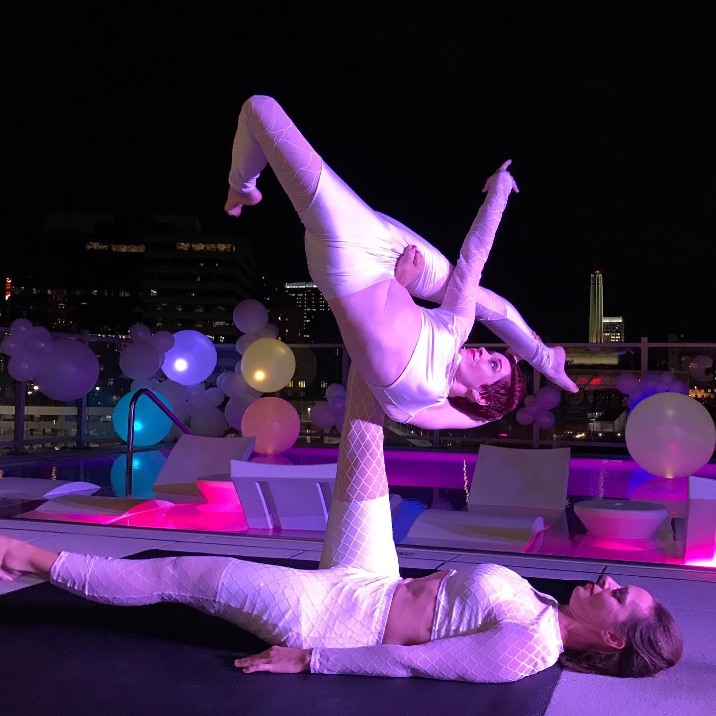 Dagney and Lacey performing acroyoga on a rooftop.